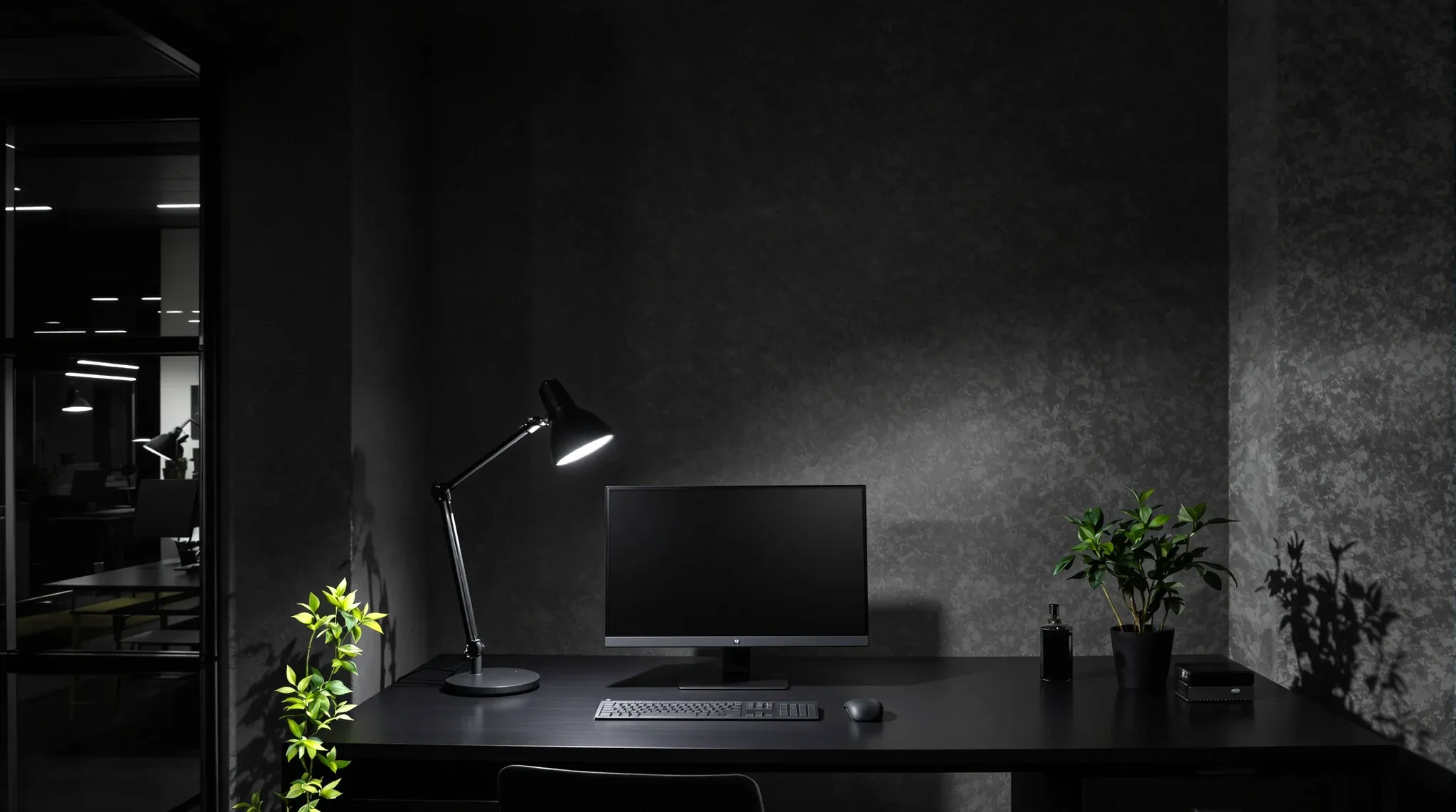 A contemporary accountancy desk at dusk, a task lamp lighting a dark monitor and a keyboard