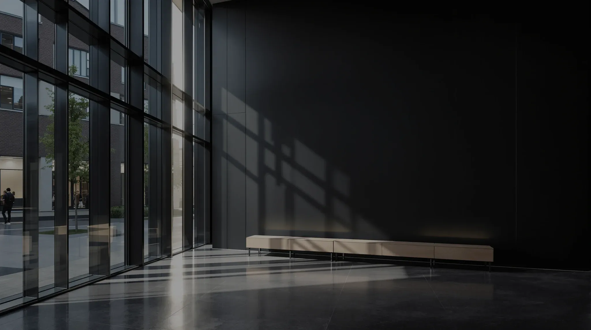 A modern school reception at dusk, timber bench seating and tall glazing onto a courtyard
